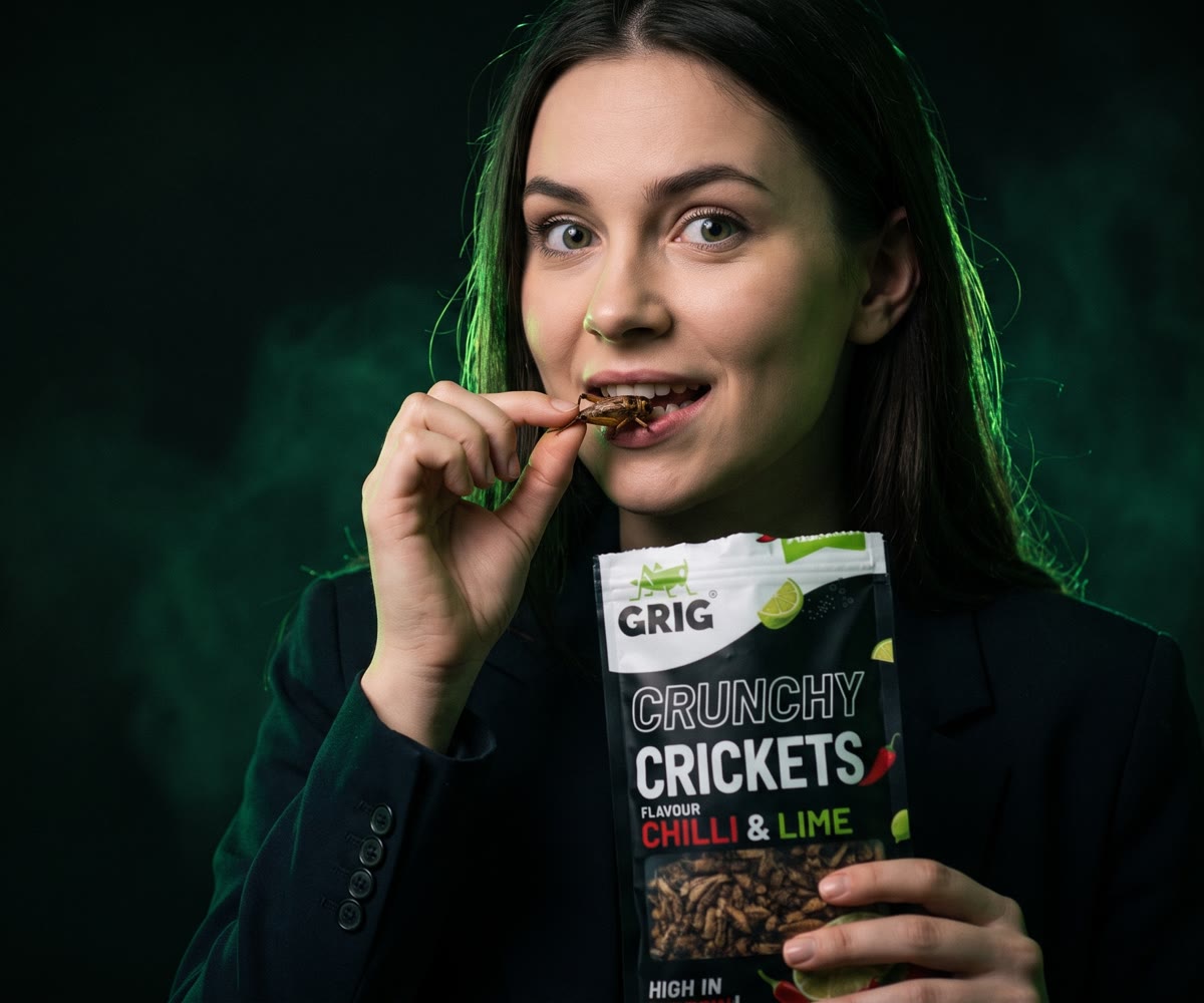 A young woman about to bite a GRIG crunchy cricket